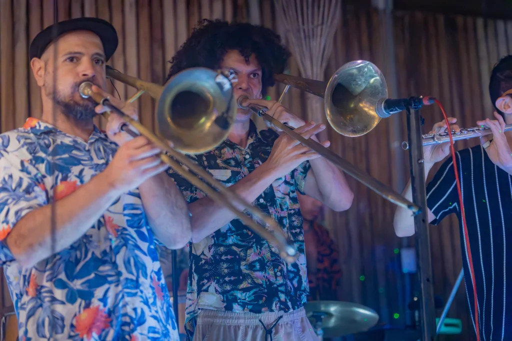 Banda de salsa con músicos tocando trombón en vivo en Azúcar Club Puerto Viejo.