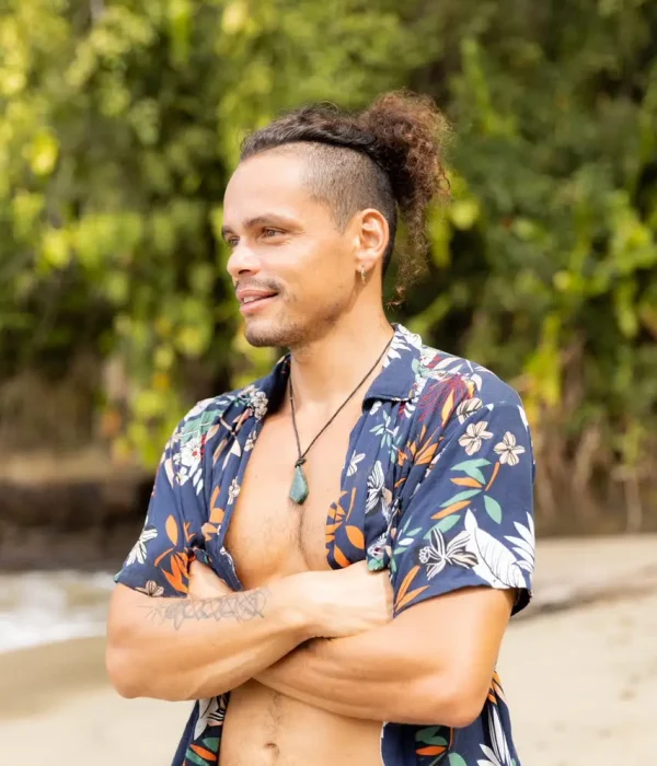 Aldo Salazar sonriendo de perfil en una sesión fotográfica en la playa de Puerto Viejo, Costa Rica.