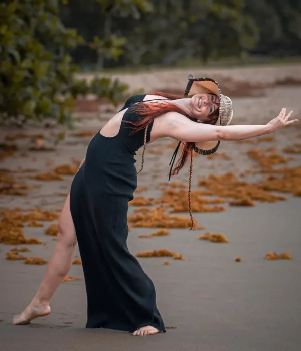 Isabel Wiskerchen ejecutando un movimiento de danza expresiva al aire libre en una playa de Costa Rica.